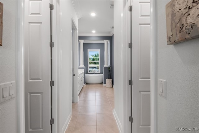 corridor with light tile patterned flooring and ornamental molding