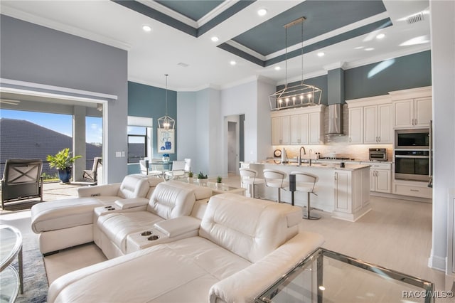 living room with ornamental molding, a towering ceiling, coffered ceiling, and sink