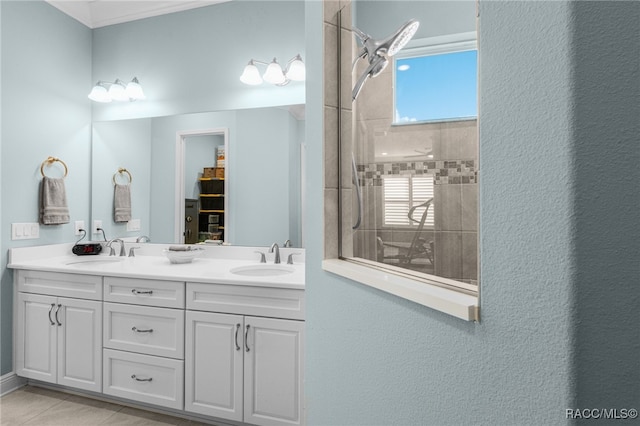 bathroom with tile patterned floors, vanity, and a tile shower