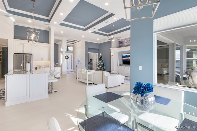 dining room with coffered ceiling, sink, a high ceiling, and ornamental molding