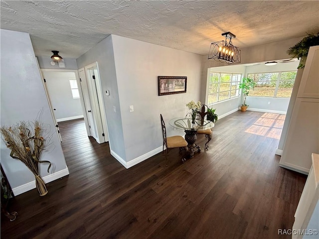 hallway featuring dark hardwood / wood-style flooring and an inviting chandelier