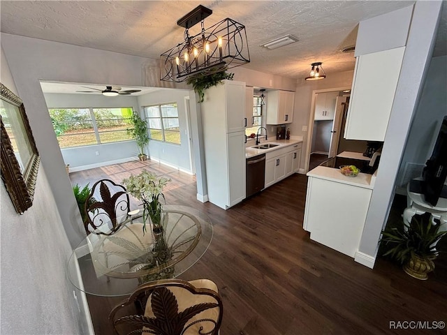 kitchen with dishwasher, white cabinets, sink, a textured ceiling, and dark hardwood / wood-style flooring