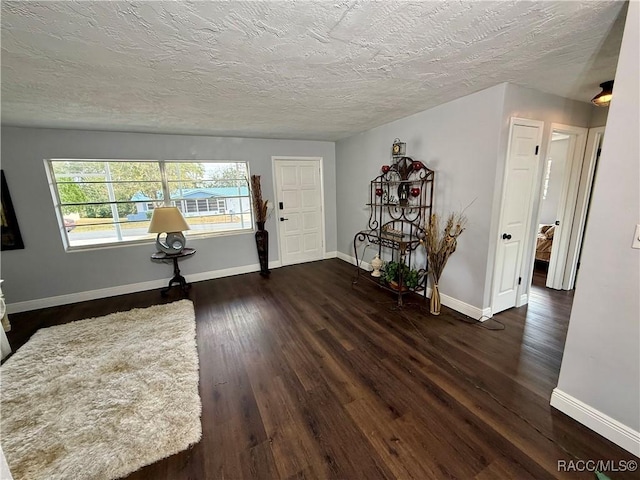 foyer entrance with a textured ceiling and dark hardwood / wood-style flooring