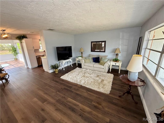 living room with dark hardwood / wood-style flooring and a textured ceiling