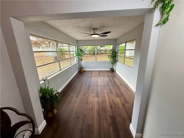 unfurnished sunroom with ceiling fan