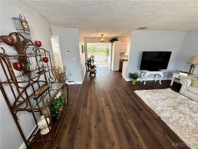 hallway with dark hardwood / wood-style flooring and a textured ceiling