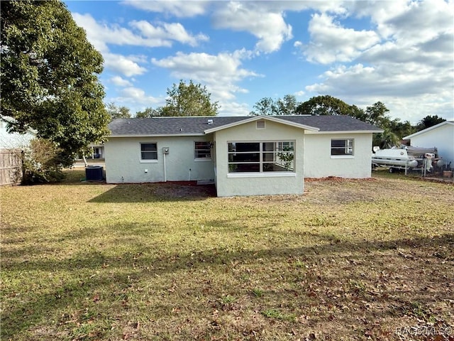 rear view of property featuring a lawn and central AC