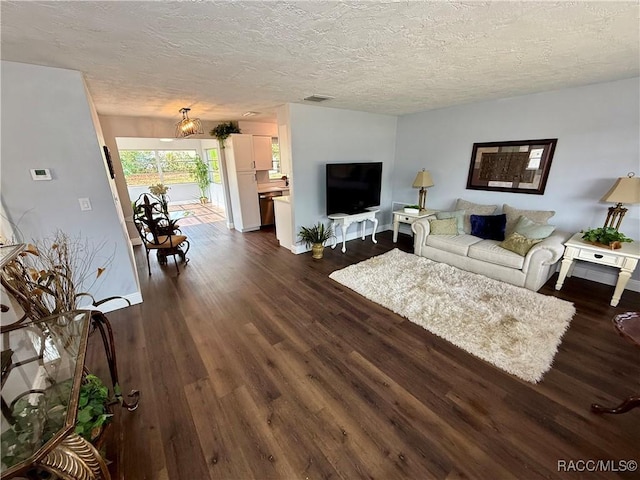 living room with dark hardwood / wood-style flooring and a textured ceiling