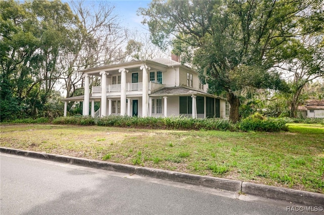 view of front of home featuring a front lawn and a balcony