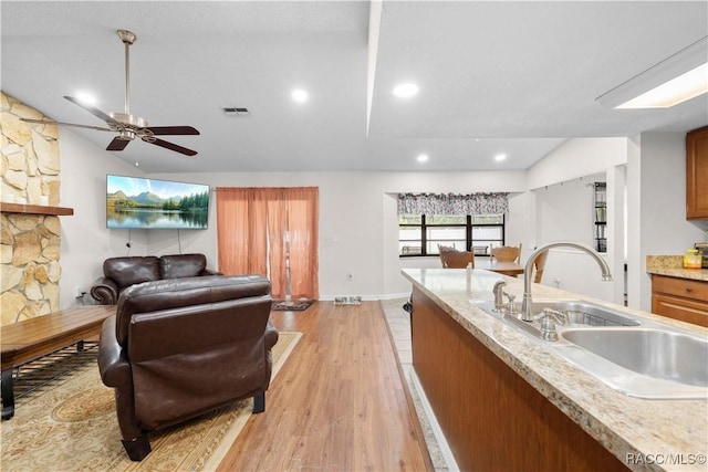 3085 Greynolds Ave, Spring Hill, FL 34608 - kitchen featuring lofted ceiling, ceiling fan, light wood finished floors, brown cabinetry, and open floor plan