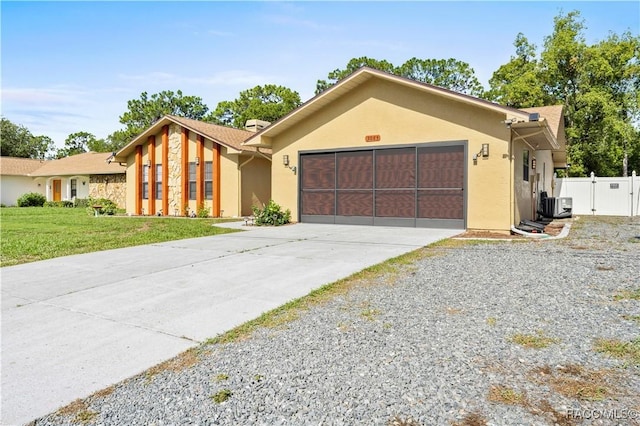 3085 Greynolds Ave, Spring Hill, FL 34608 - view of front facade featuring an attached garage, concrete driveway, stucco siding, and a gate