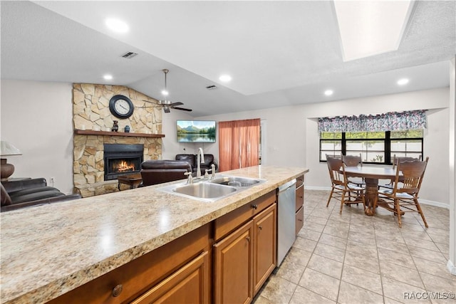3085 Greynolds Ave, Spring Hill, FL 34608 - kitchen featuring dishwasher, a fireplace, lofted ceiling, brown cabinets, and open floor plan