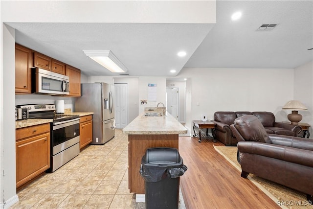 3085 Greynolds Ave, Spring Hill, FL 34608 - kitchen with stainless steel appliances, open floor plan, light countertops, brown cabinets, and recessed lighting