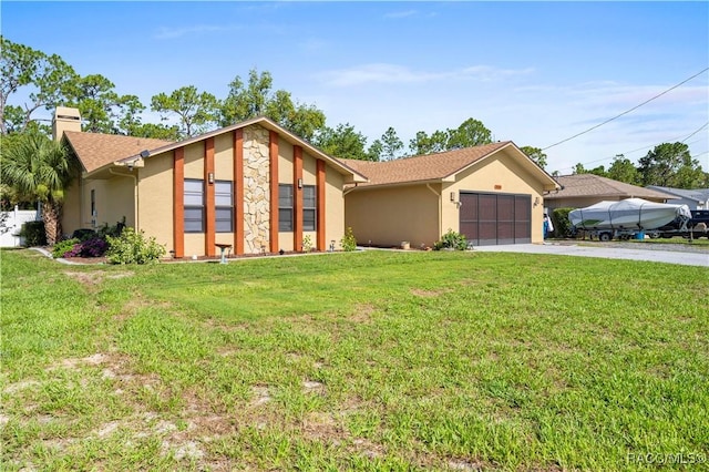 3085 Greynolds Ave, Spring Hill, FL 34608 - view of front facade featuring stucco siding, concrete driveway, a garage, and a chimney