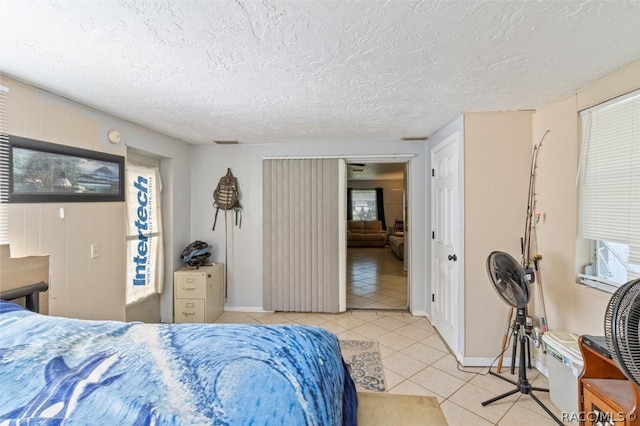 bedroom with light tile patterned floors and a textured ceiling