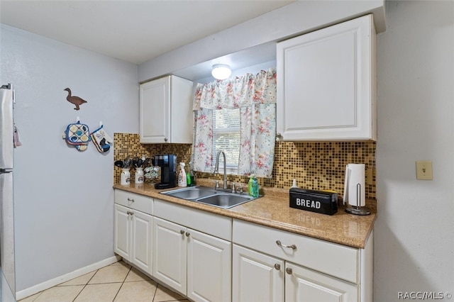 kitchen featuring white cabinetry, decorative backsplash, sink, and light tile patterned floors