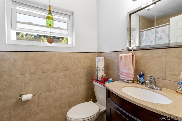 bathroom featuring vanity, tile walls, and toilet