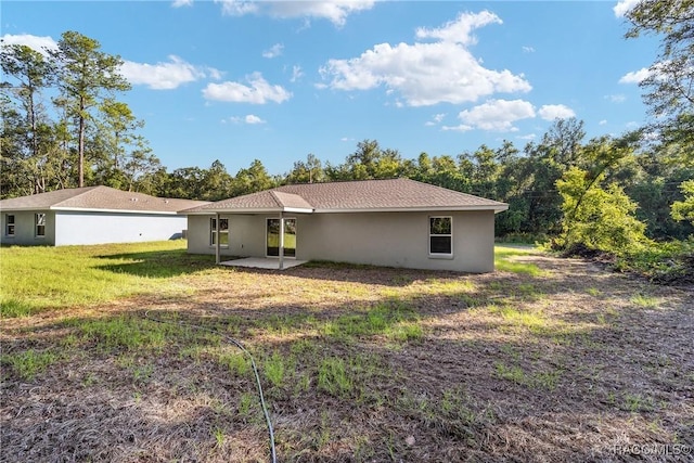 back of property featuring a yard and a patio