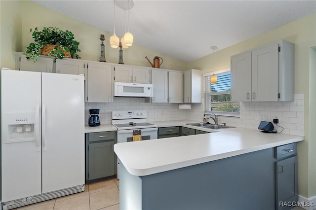 kitchen featuring kitchen peninsula, white appliances, vaulted ceiling, sink, and pendant lighting