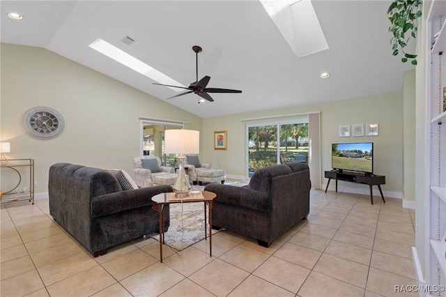 tiled living room with ceiling fan and lofted ceiling with skylight