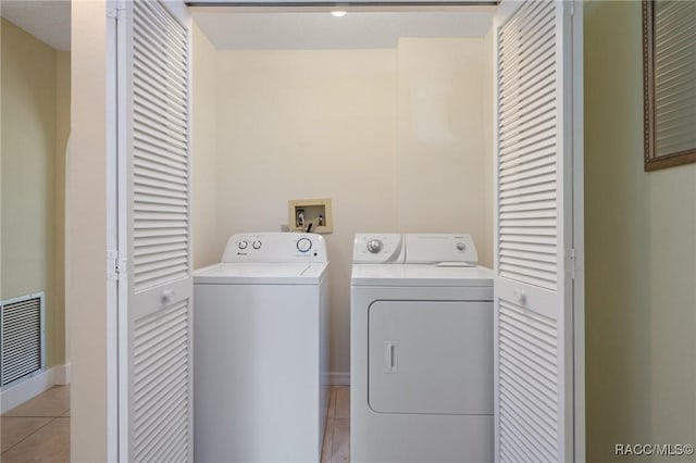 washroom with light tile patterned floors and washing machine and dryer