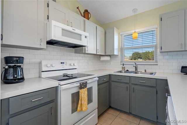 kitchen featuring gray cabinetry, sink, hanging light fixtures, white appliances, and light tile patterned floors