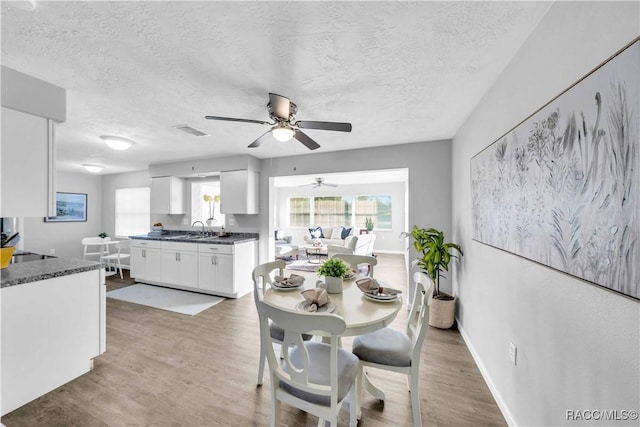28 Truman Blvd, Beverly Hills, FL 34465 - dining room with a textured ceiling, light wood finished floors, a ceiling fan, and baseboards