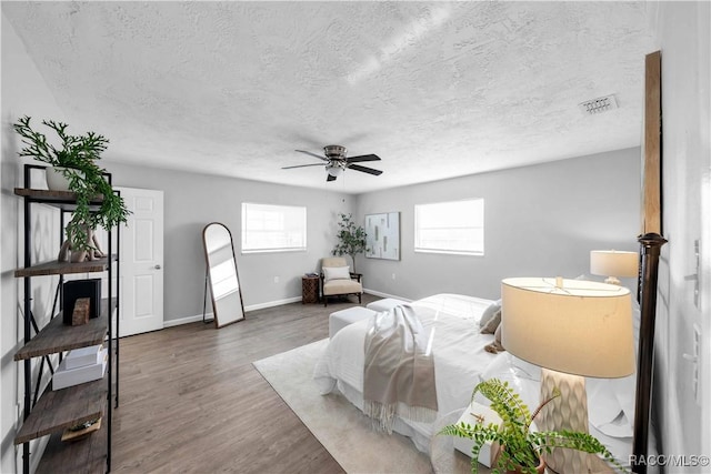 28 Truman Blvd, Beverly Hills, FL 34465 - bedroom featuring multiple windows, a textured ceiling, wood finished floors, baseboards, and a ceiling fan