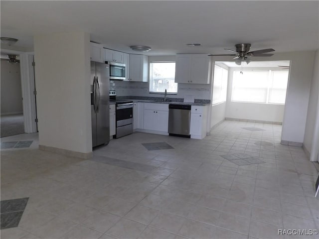 kitchen with ceiling fan, sink, stainless steel appliances, light tile patterned floors, and white cabinets