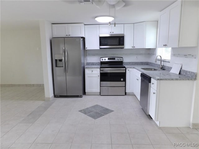 kitchen with sink, white cabinets, stainless steel appliances, and light tile patterned floors