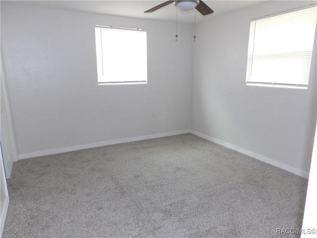 carpeted spare room featuring ceiling fan