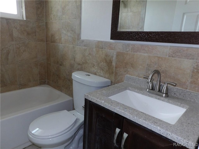 full bathroom featuring tasteful backsplash, vanity, tile walls, washtub / shower combination, and toilet