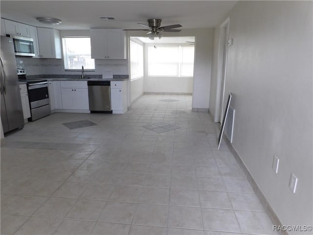 kitchen with light tile patterned floors, white cabinetry, sink, and appliances with stainless steel finishes