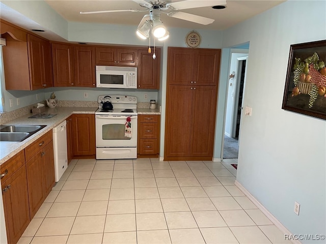 kitchen featuring ceiling fan, white appliances, sink, and light tile patterned floors