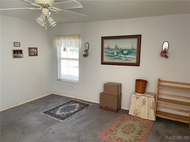 interior space with ceiling fan and dark carpet