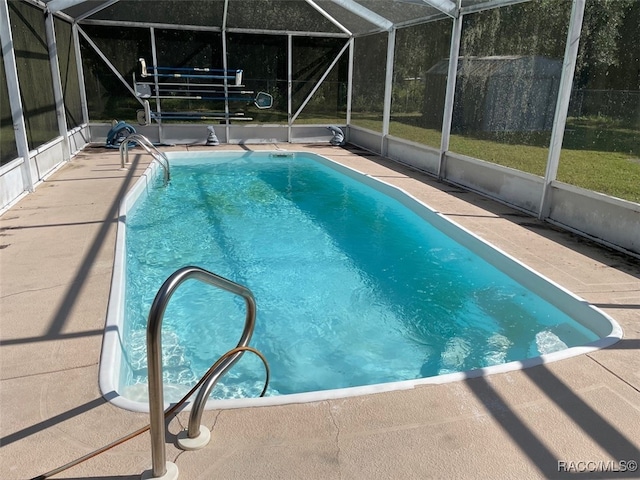 view of pool featuring glass enclosure