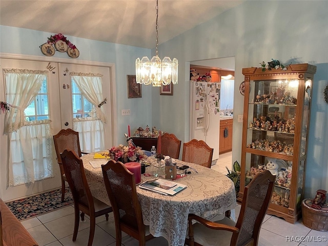 dining area with vaulted ceiling, light tile patterned flooring, french doors, and a chandelier