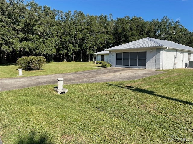 view of front of home featuring a garage, central AC, and a front lawn