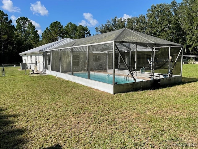 view of pool with glass enclosure and a yard