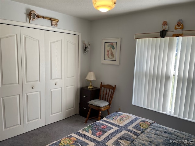 carpeted bedroom with a textured ceiling and a closet