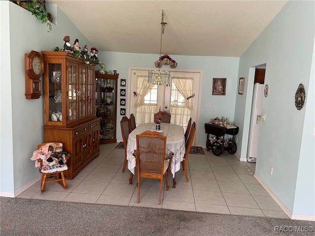 dining space with a chandelier, french doors, vaulted ceiling, and light tile patterned flooring