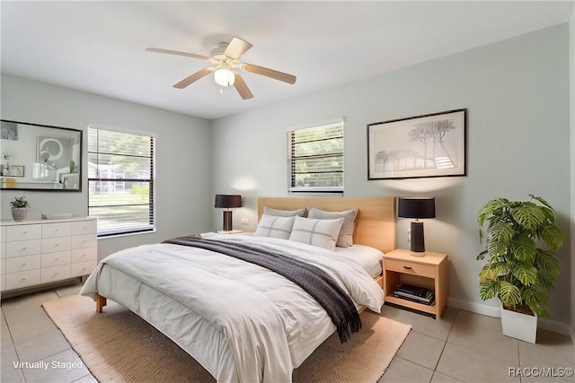 bedroom with light tile patterned floors, a ceiling fan, and baseboards