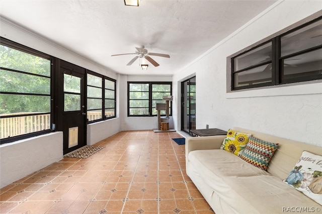 interior space with crown molding, a textured wall, a textured ceiling, and ceiling fan