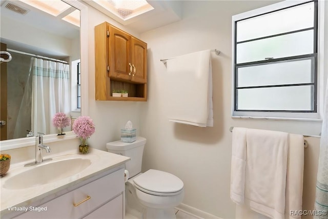 full bathroom with toilet, a shower with shower curtain, vanity, and visible vents