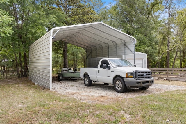 view of parking / parking lot with a carport, driveway, and fence