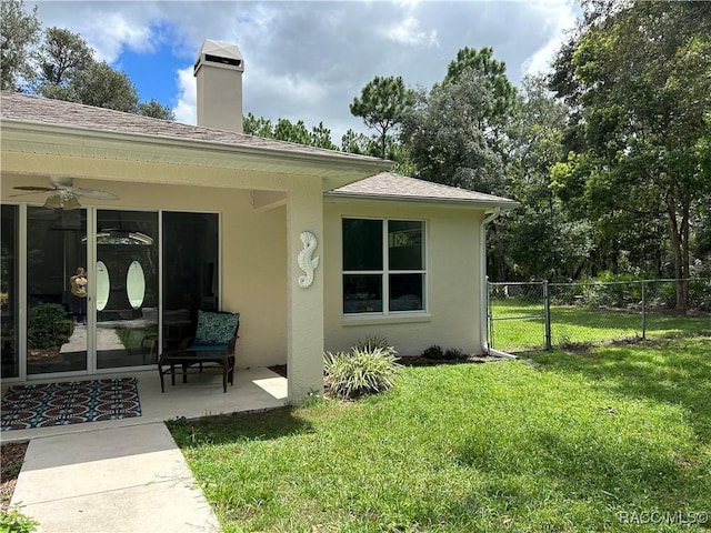5774 N Lamp Post Dr, Beverly Hills, FL 34465 - rear view of house with ceiling fan, stucco siding, a patio, a chimney, and roof with shingles
