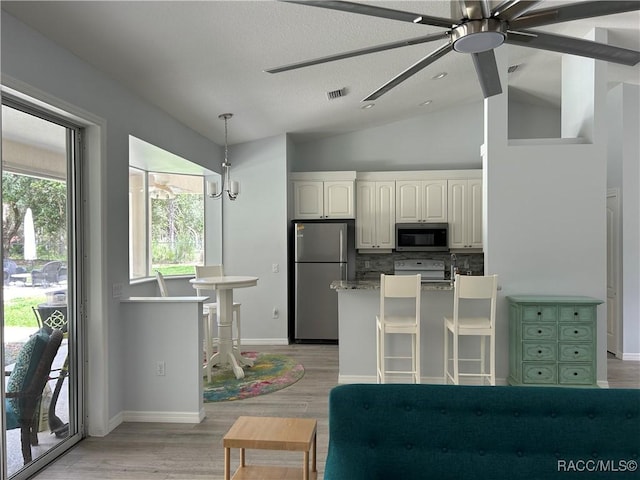 5774 N Lamp Post Dr, Beverly Hills, FL 34465 - kitchen featuring stainless steel appliances, a ceiling fan, vaulted ceiling, decorative backsplash, and white cabinetry