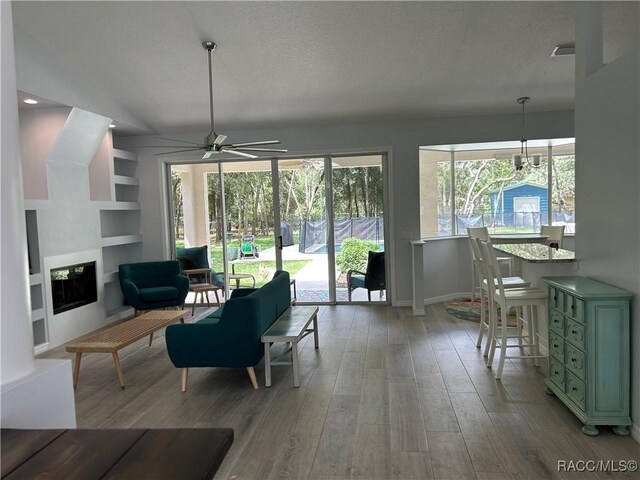 5774 N Lamp Post Dr, Beverly Hills, FL 34465 - living area featuring a ceiling fan, wood finished floors, built in features, and a glass covered fireplace