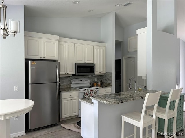 5774 N Lamp Post Dr, Beverly Hills, FL 34465 - kitchen featuring stainless steel appliances, backsplash, light wood finished floors, a peninsula, and light stone countertops