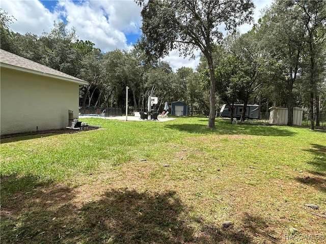 5774 N Lamp Post Dr, Beverly Hills, FL 34465 - view of grassy yard with a shed, a detached garage, and view of wooded area
